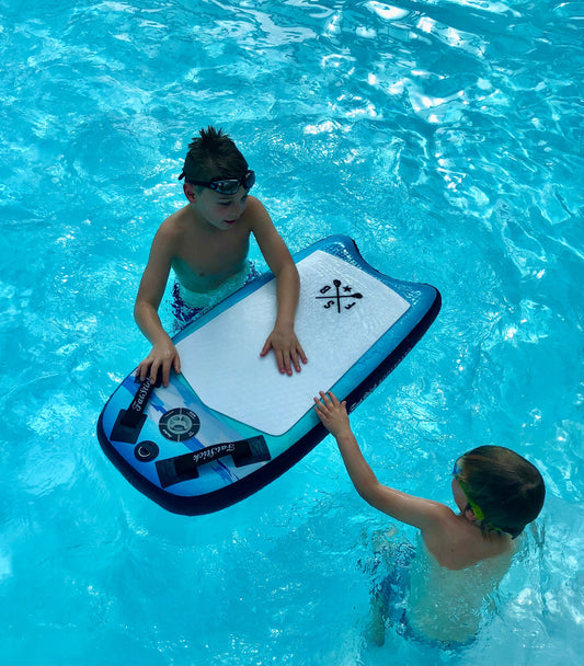Two young boys playing in a swimming pool with the Inflatable 43 Fatstick Body Board, one holding onto the board.