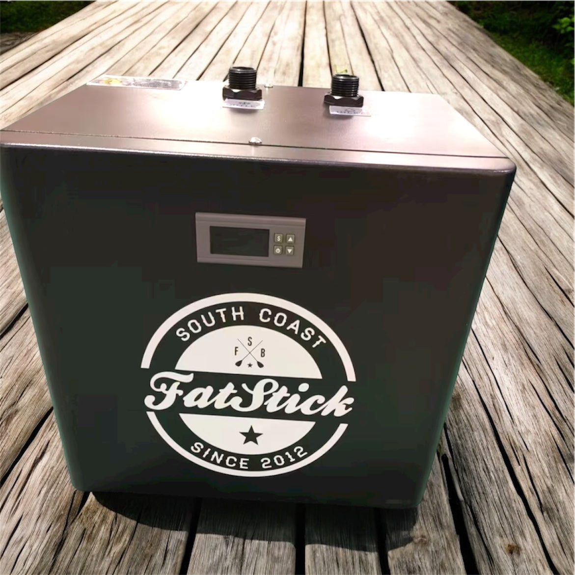 Top-down view of the black FatStick Boards home chiller unit for ice baths sitting on a wooden deck