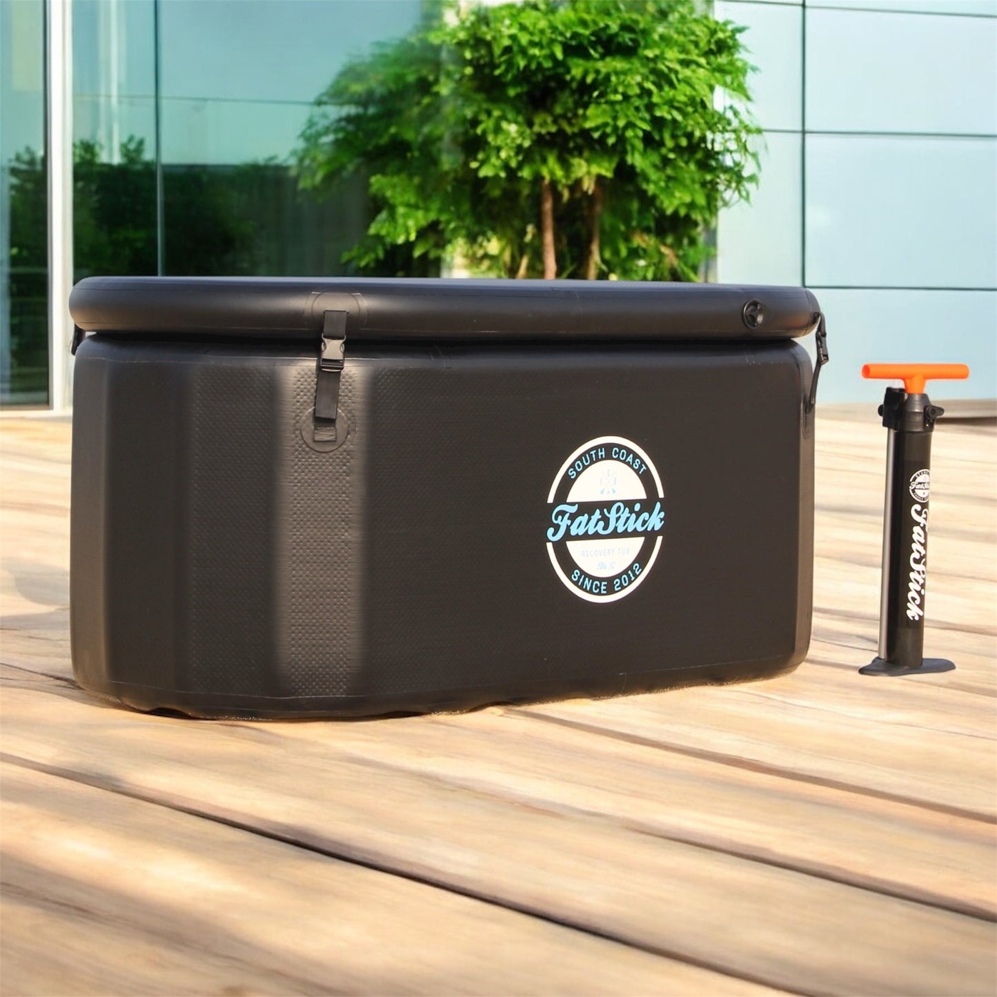 FatStick pro cold water therapy plunge tub with pump, set outdoors on deck beside building.