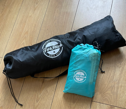Black bag for the Fatstick Beach Tent sun shade and a smaller blue bag for ground sheet.