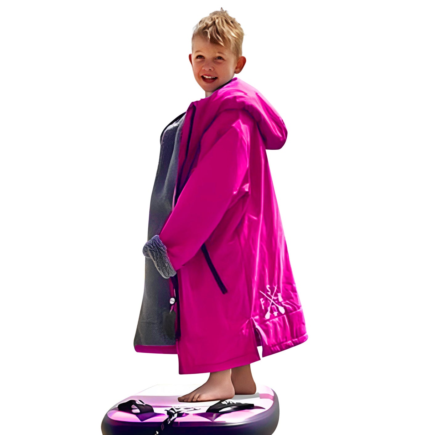 Young boy in pink FatStick Kids FatWrap changing robe with sherpa fleece lining, smiling, on paddleboard.