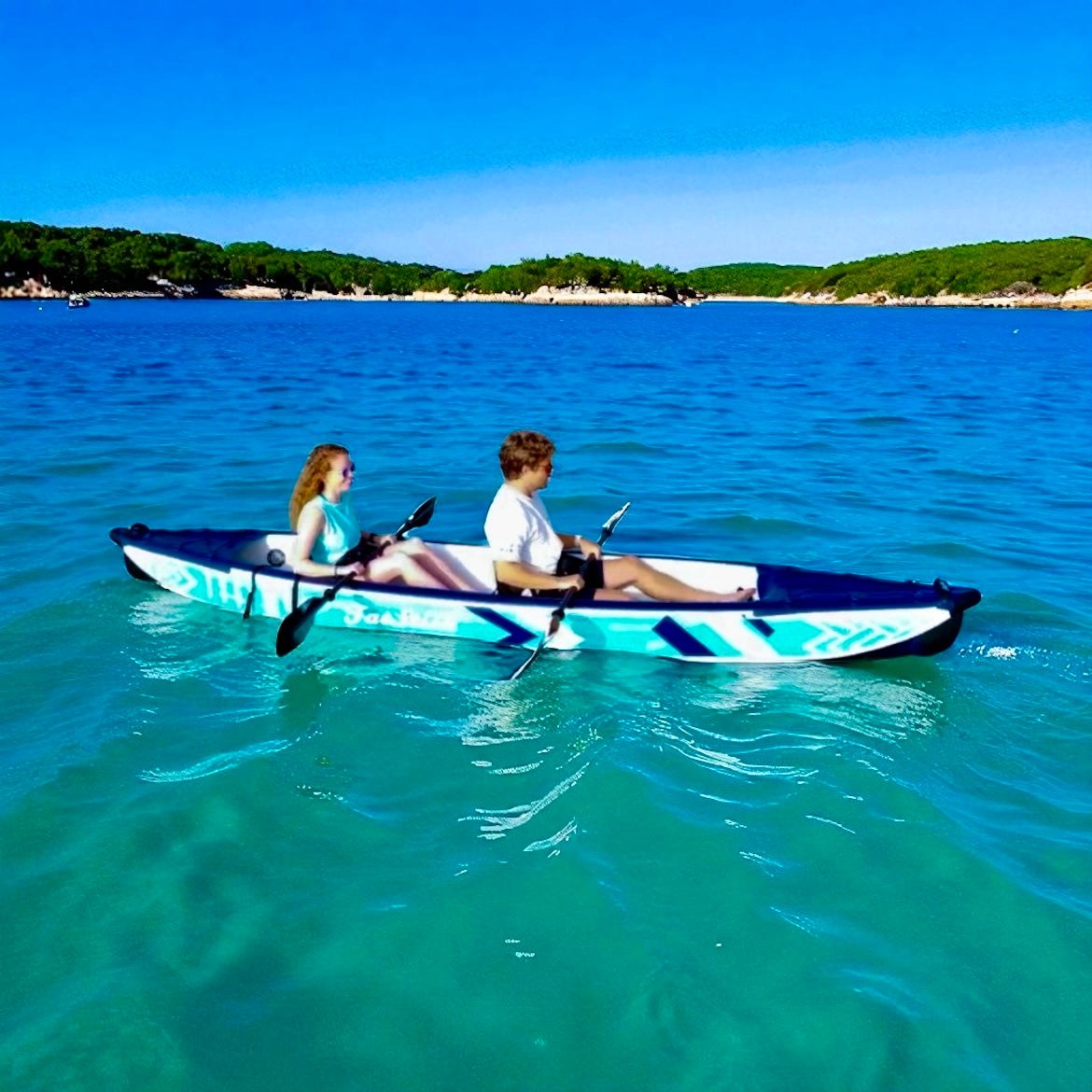 Two people paddling the inflatable 1-2 person drop stitch kayak package canoe ikayak on blue water.
