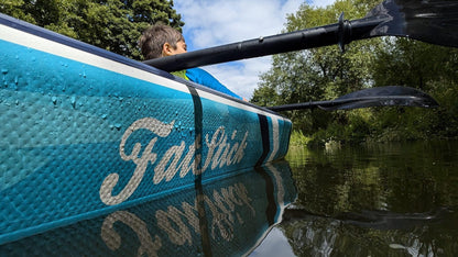 Close-up of a child in the inflatable 1-2 person drop stitch kayak package canoe ikayak on the water.