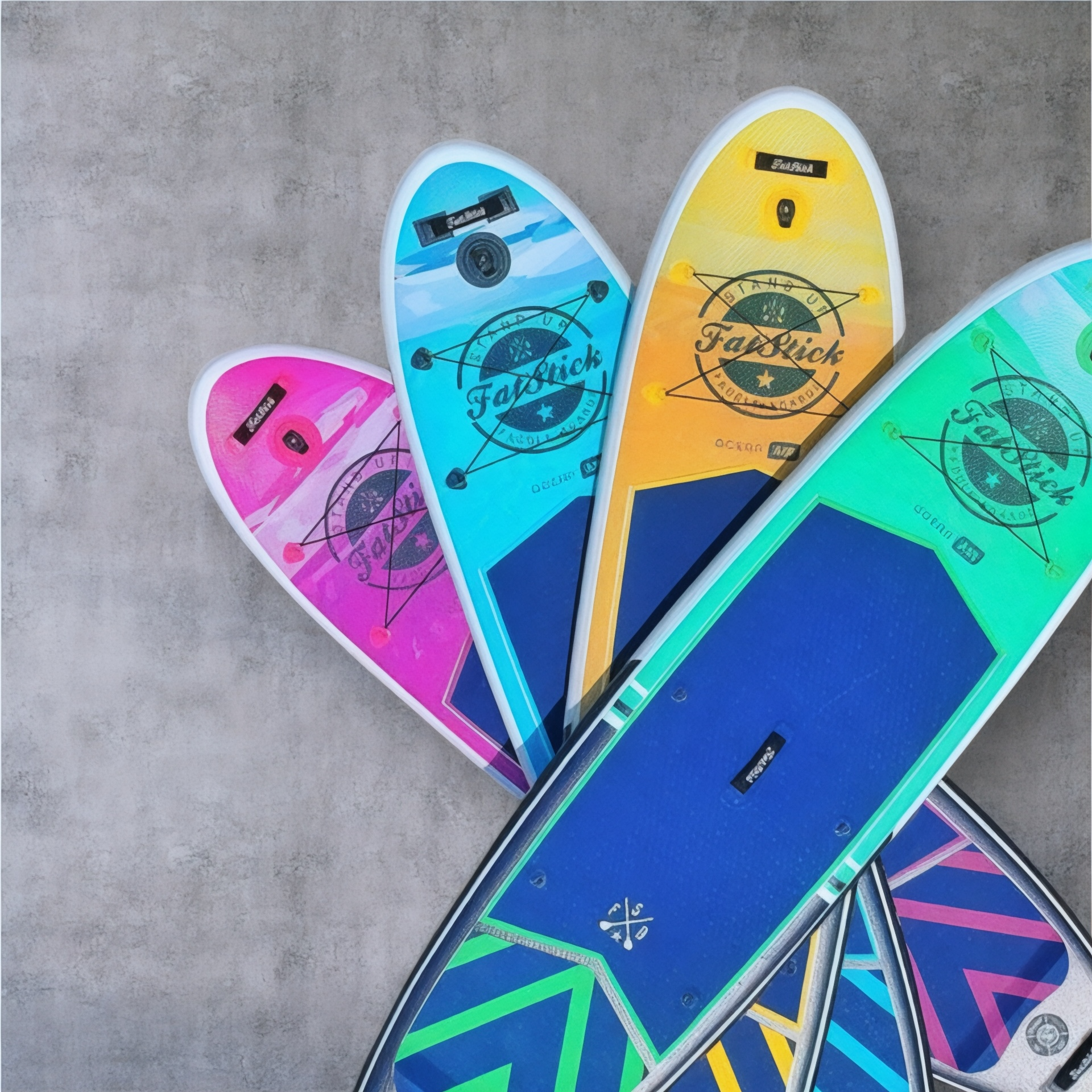 Four Pure Art 10'6 inflatable paddle boards in pink, blue, yellow, and green, fanned out on a concrete surface.