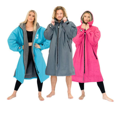 Three models wearing different colored FatWrap recycled fleece changing robes: blue, grey, and pink, standing barefoot.